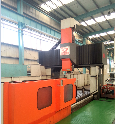 Orange 6 m CNC gantry milling machine on a green workshop floor
