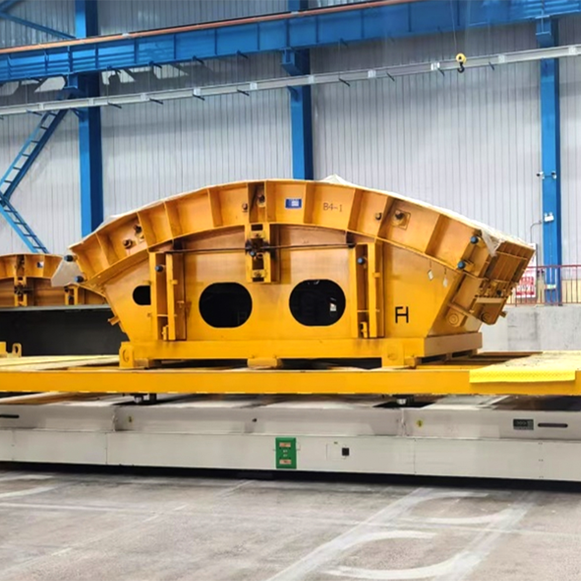 Heavy-duty AGV carrying a yellow segment mould in a workshop